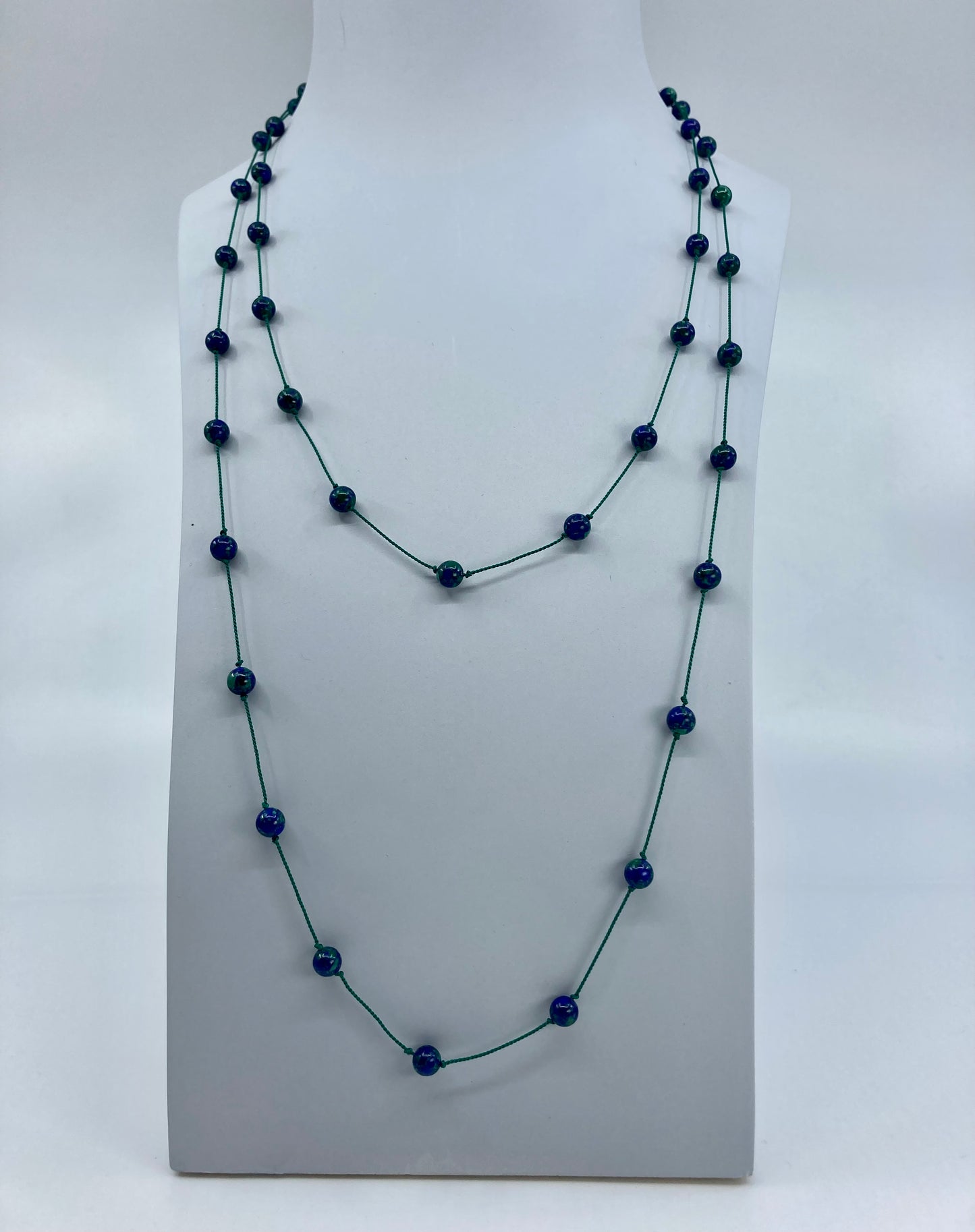 Azurmalachite beads threaded and spaced out on silk cord with sterling silver clasp doubled over display bust