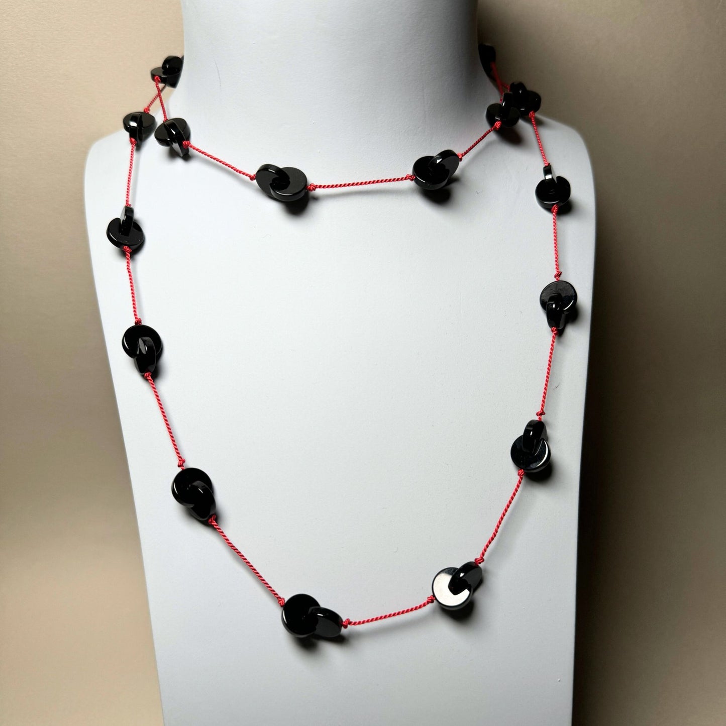 Interlocking onyx beads long necklace on red silk