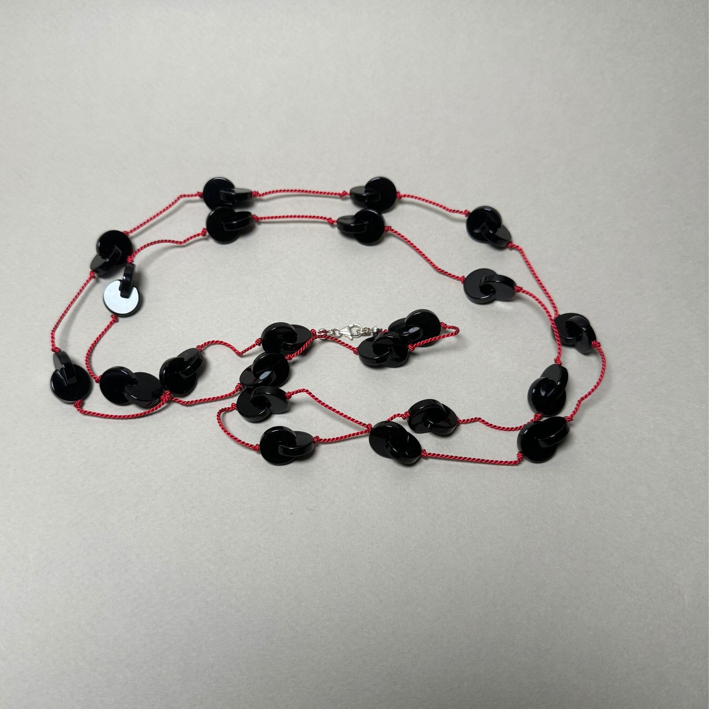 Interlocking onyx beads long necklace on red silk