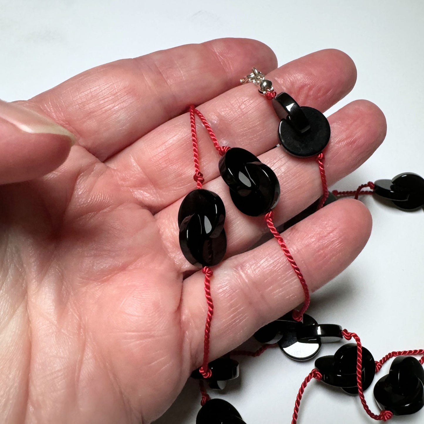 Interlocking onyx beads long necklace on red silk