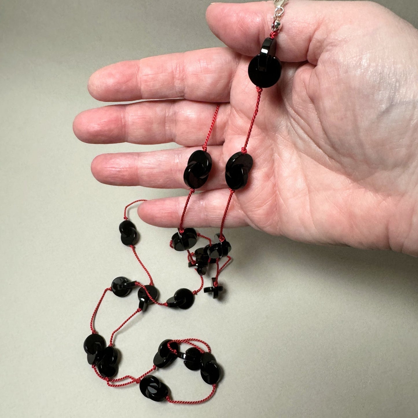 Interlocking onyx beads long necklace on red silk